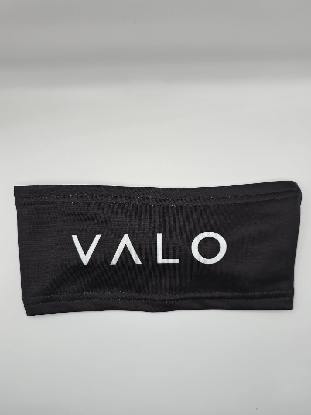 A black fabric headband with the brand name 'VALO' printed in white capital letters across the front, displayed on a neutral light gray background.