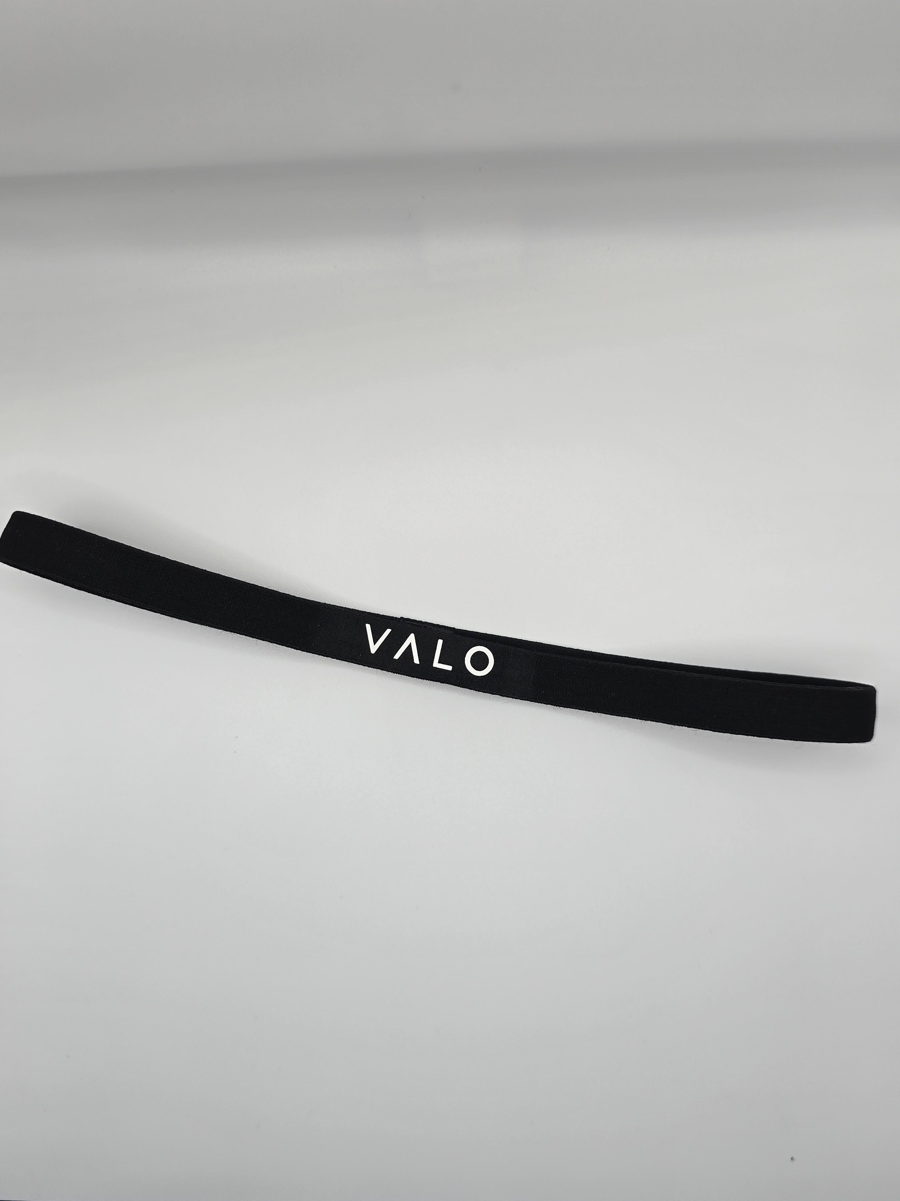 A black elastic headband with the brand name 'VALO' printed in white capital letters, displayed on a light gray background.