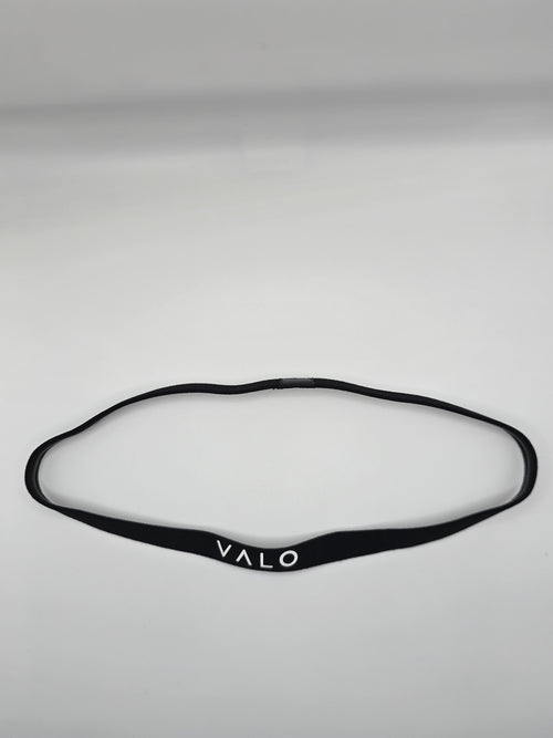 A black silicone headband with the brand name 'VALO' printed in white on the front, laid flat on a light gray background.